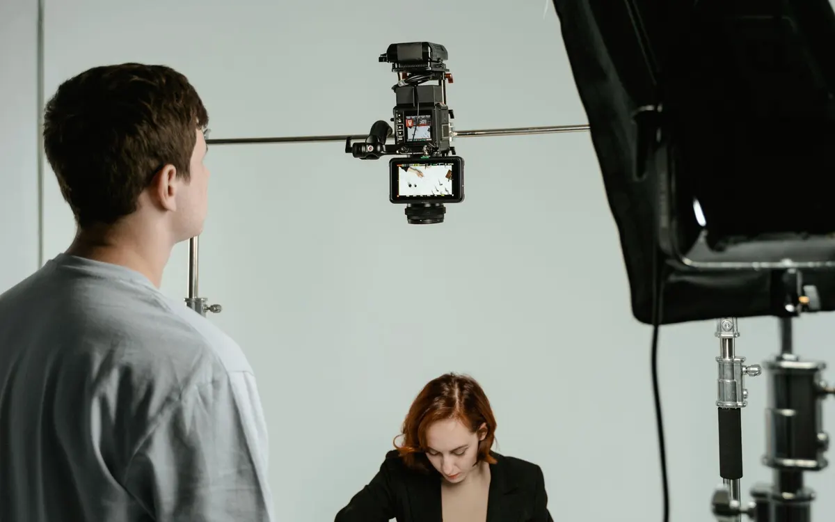 Studio shoot with a camera on a rig, a light, and a woman working at a table